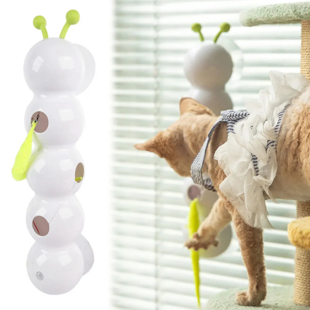 Cat playing with a toy shaped like a white caterpillar with green antennae.