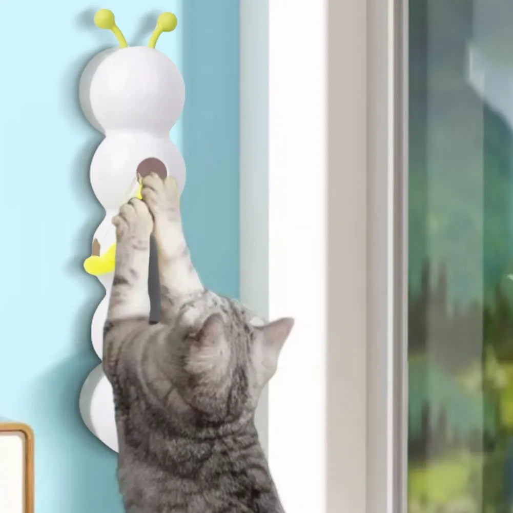 Cat playing with a wall-mounted cat toy shaped like a snail.